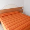 Camera da letto con letto matrimoniale e copriletto arancione.