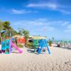 Spiaggia con giochi per bambini e lettini colorati.