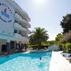 Piscina all'aperto con palme e edificio bianco.