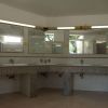 Interno di bagno con specchi, lavandini e luci al neon.