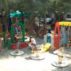 Parco giochi all'aperto con bambini e attrezzature colorate.