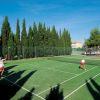 Due persone giocano a tennis su un campo verde.