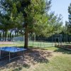 Tavolo da ping pong all'aperto vicino a campo sportivo.