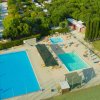 Due piscine all'aperto con lettini e ombrelloni.