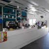 Interno di un bar moderno con bancone bianco.