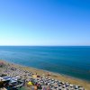Spiaggia con ombrelloni e mare blu.