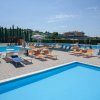 Area piscina con lettini e ombrelloni.