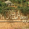 Un'insegna di resort incorniciata da piante verdi.