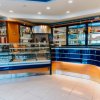 Interno di un bar moderno con espositori refrigerati e bancone blu.
