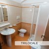 Bagno con lavandino, WC e doccia in un trilocale.
