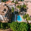 Vista aerea di un complesso residenziale con piscina centrale e numerosi alberi attorno.