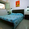 Camera da letto con letto matrimoniale, copriletto blu a fiori e quadro sul muro.