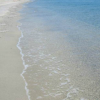 Spiaggia sabbiosa con onde leggere che accarezzano la riva.