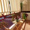 Balcone con tende a rullo, tavolo pieghevole, sedia e pianta decorativa.