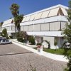 Edifici moderni con terrazze e giardino, lungo una strada lastricata.
