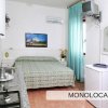 Un monolocale con letto matrimoniale, cucina e televisore.