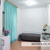 Monolocale con letto singolo, cucina e frigorifero in uno spazio compatto.
