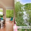 Terrazza con tavolo, sedie e vegetazione rigogliosa attorno.