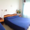 Camera d'albergo con letti blu e fiori.