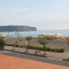 Spiaggia con ombrelloni e mare in lontananza.