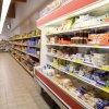 Una corsia di supermercato con scaffali pieni di prodotti alimentari e latticini.