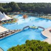 Ampia piscina vista dall'alto, con ombrelloni e un'area relax.