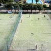 Due campi da calcetto verdi con giocatori, visti dall'alto.