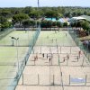 Campi sportivi esterni con attività di calcio e pallavolo su sabbia.