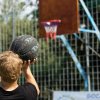 Persona lancia una palla in un canestro da basket.