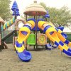 Parco giochi con scivoli colorati e strutture in legno.