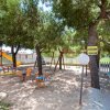 Un parco giochi con scivolo, altalene e un albero.