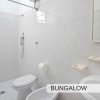 Bagno con doccia, WC e lavandino, piastrelle bianche.
