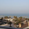 Vista mare, palme e edifici in primo piano.