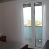 Stanza con letto, porta finestra e vista mare.