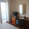 Scrivania con TV, sedia e porta finestra.