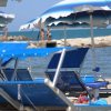 Lettini blu e ombrelloni in spiaggia.