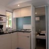 Cucina moderna con microonde e fornelli, accanto a una camera da letto.